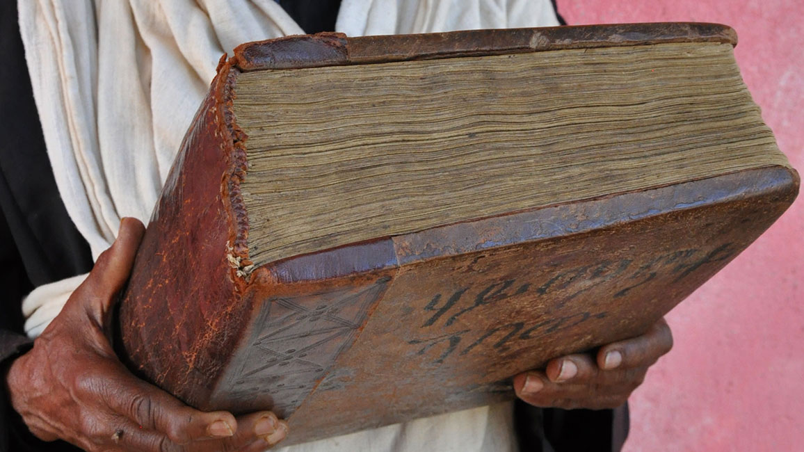 Ein Priester hält eine Handschrift aus dem 17. Jh. (Äthiopien, Dabra Dāmmo, HS Ethio-SPaRe DD-007, Auszüge aus den Kirchenväter)