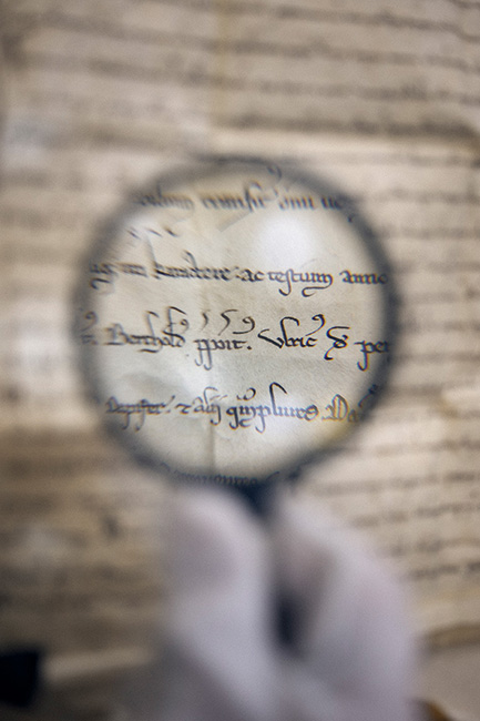 Ansicht Lupe und alte hanschriftliche Urkunde
