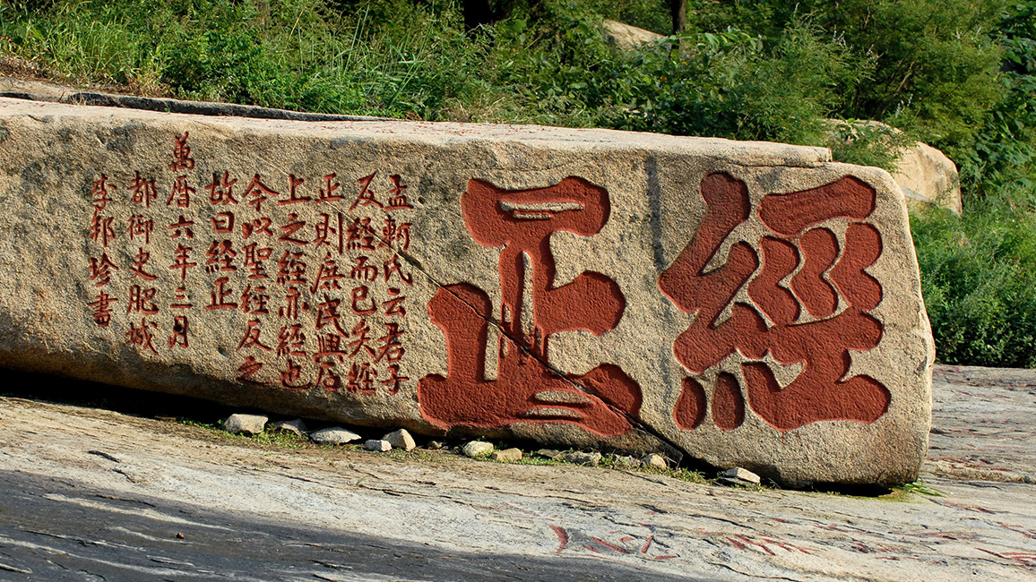 Mit den beiden Kolossalzeichen „Standard berichtigt" aus einem klassischen konfuzianischen Text und seinem anschließenden Kommentar in kleinen Zeichen versucht der Zensor Li Bangzhen im Jahr 1579 den bislang buddhistischen Charakter des Tals mit dem Steinsutra zu konfuzianisieren.
