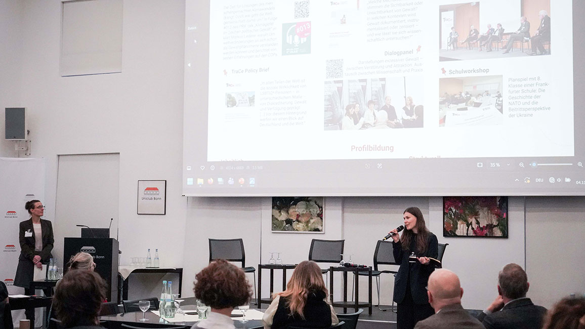 Eine Person hält vor Publikum einen Vortrag