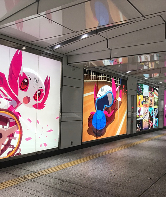 Walkway in Tokyo‘s busiest train station, decorated with the Olympic mascots