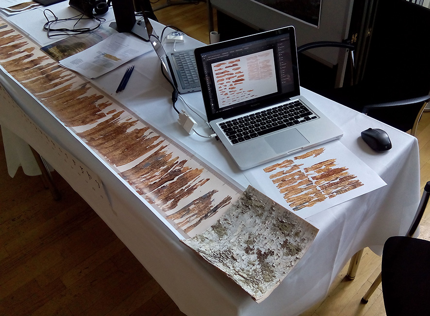 Tisch mit alten Handschriften auf Birkenrinde und Laptop
