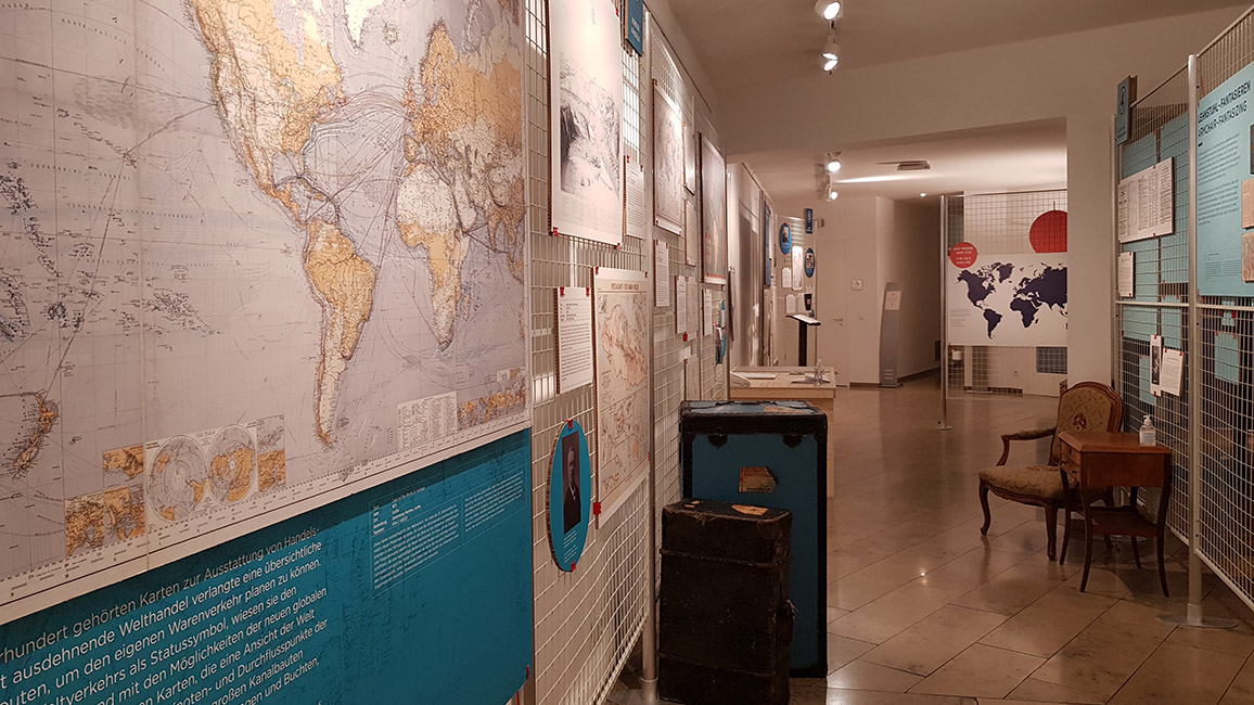 Einblick ins Ausstellungsraum mit alten Landkarten an der der Wand